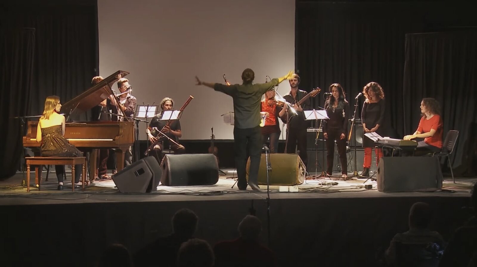 Ensamble Argentino de Improvisadores in concert, the conductor with arms raised