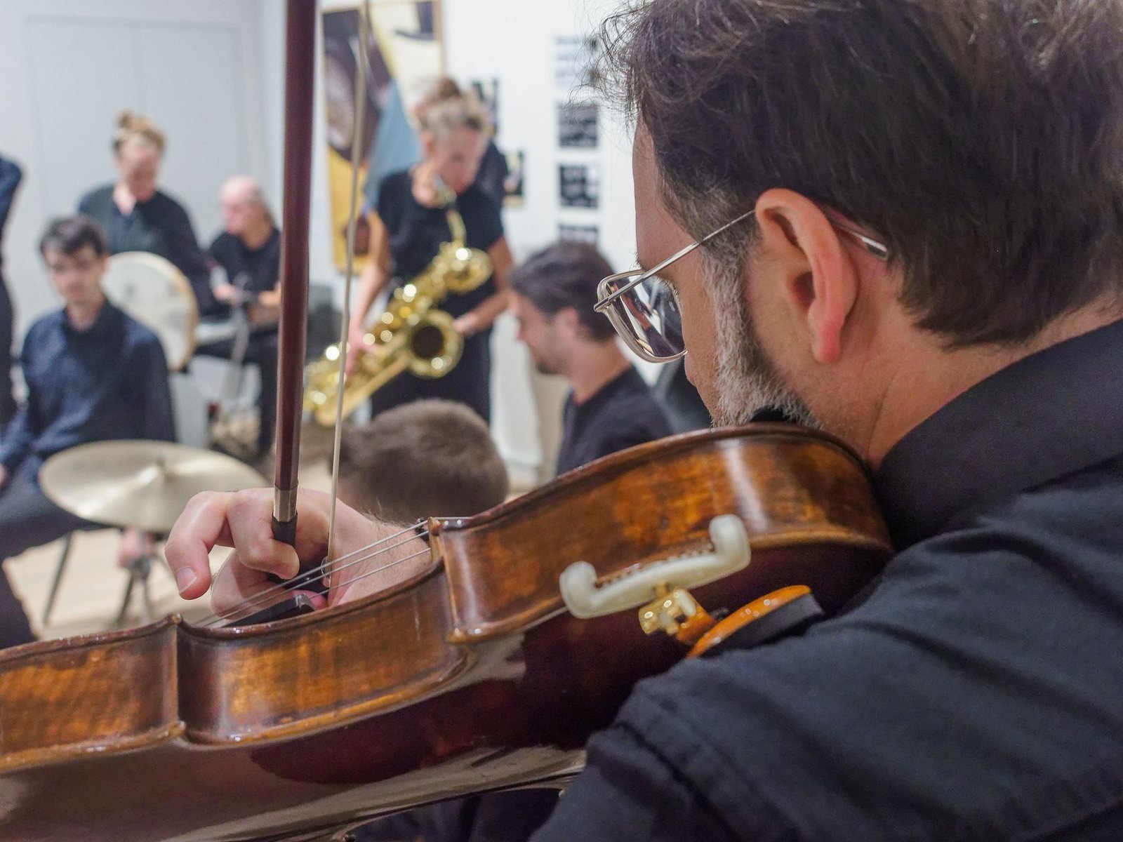 Close view of the viola in the GONG-Improvisationsorchester, with other musicians behind