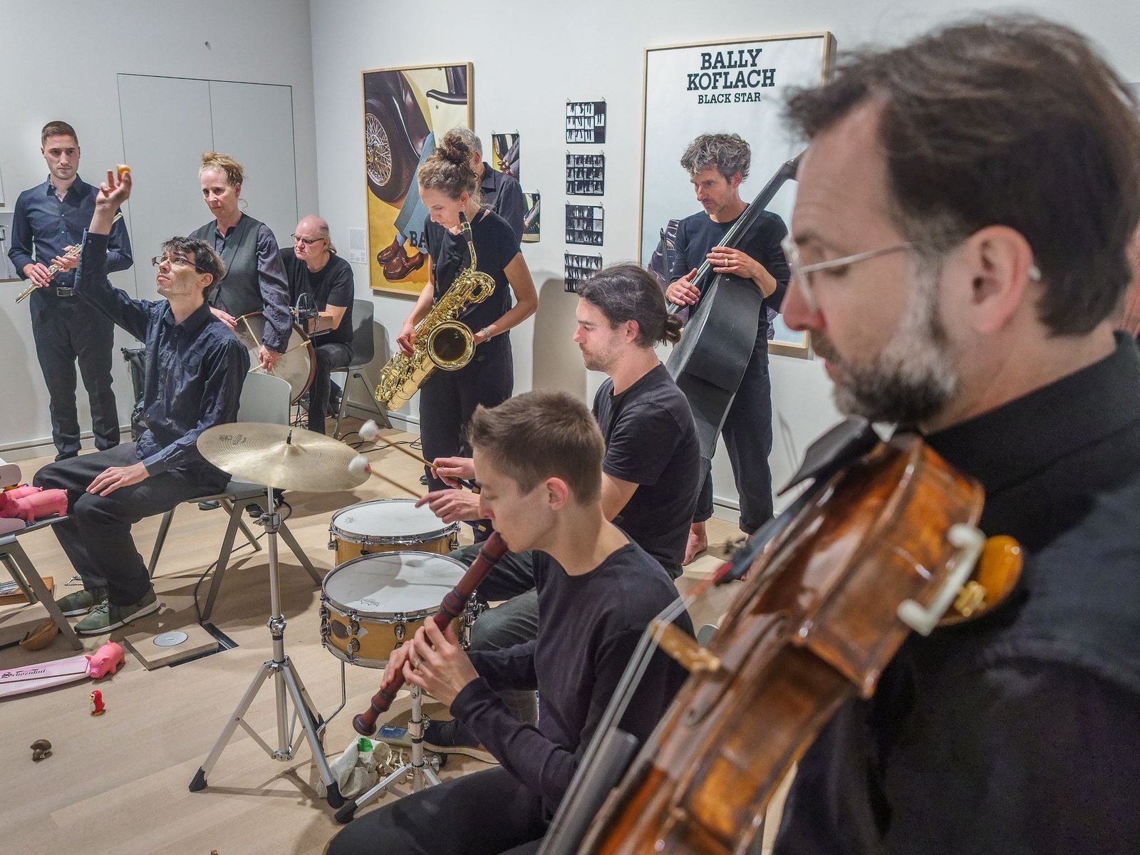 A viola player in the foreground among the musicians of the GONG-Improvisationsorchester in the museum rooms