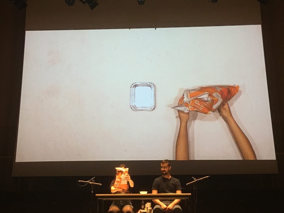 Rehearsal: on the screen, hands lift an orange bag of crisps next to an empty tray