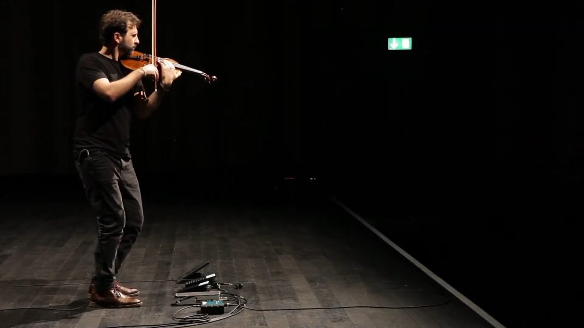 Diego Kohn playing violin, his foot near the volume pedals