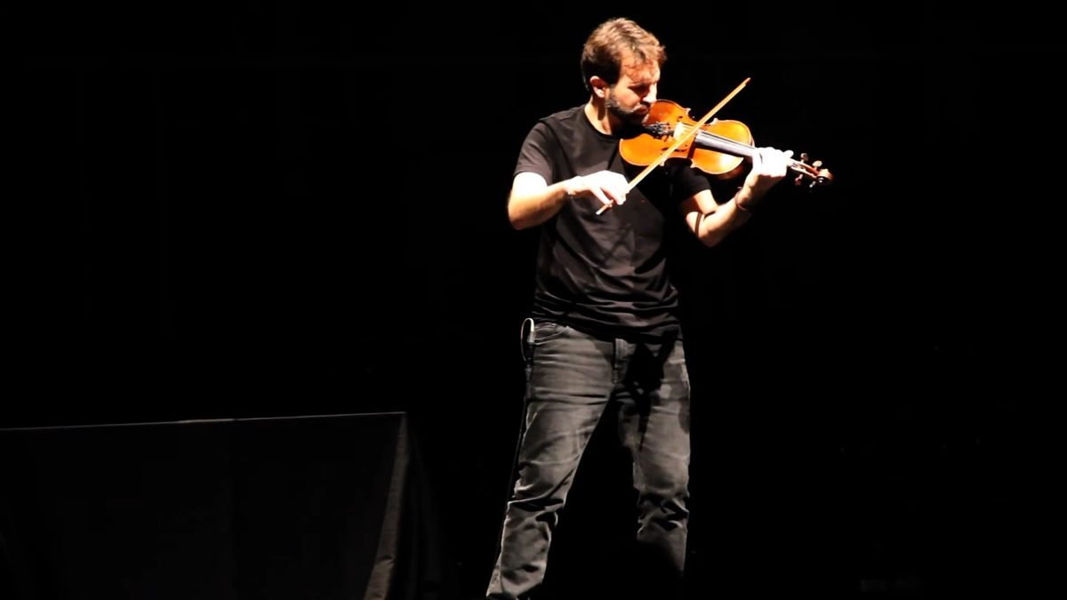 Diego Kohn playing violin, seen from the front in the stage light