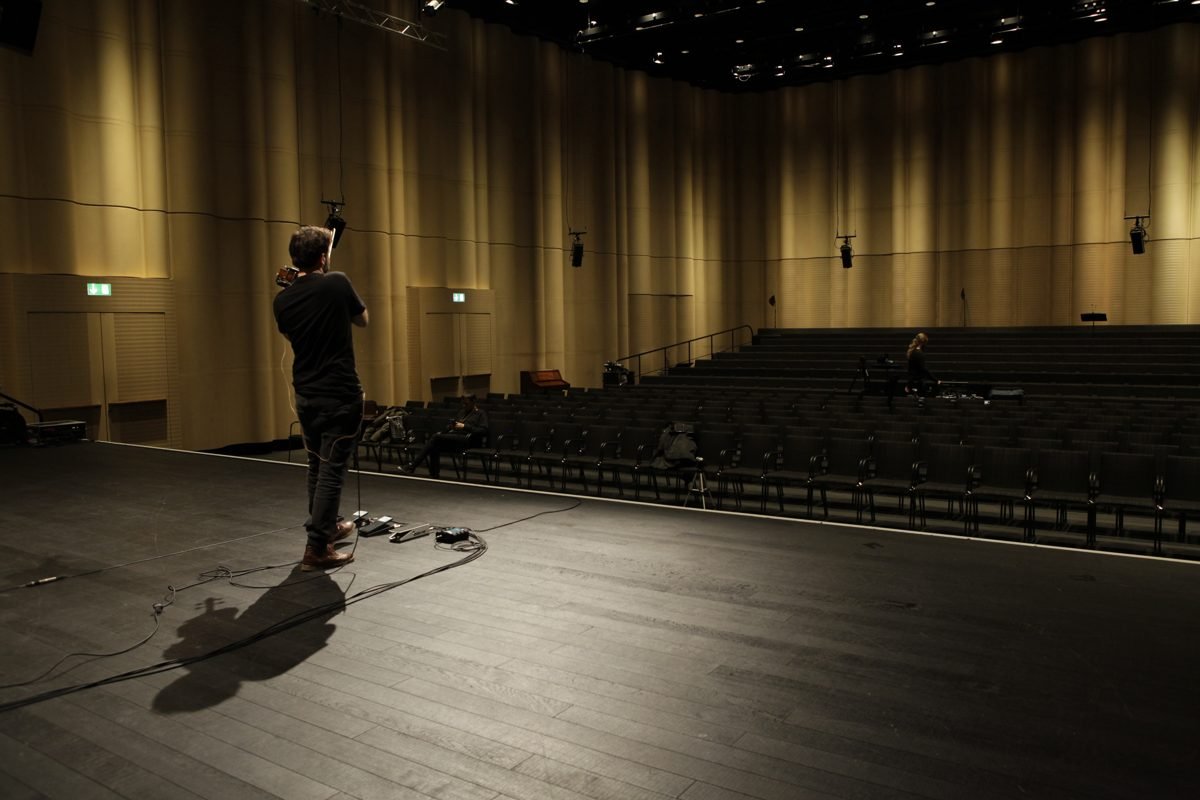Diego Kohn seen from behind, playing toward the empty hall
