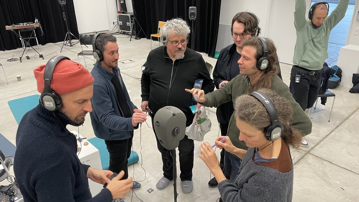 Participants with headphones around a binaural head during the residency
